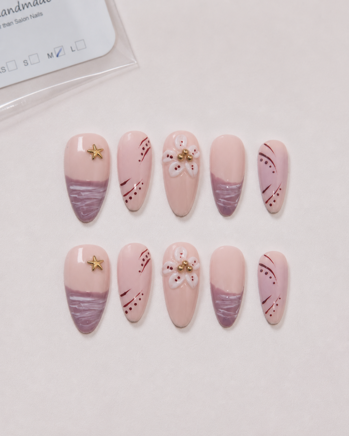Ten blush and mauve Mauve Starlight almond press-on nails arranged as a complete set.