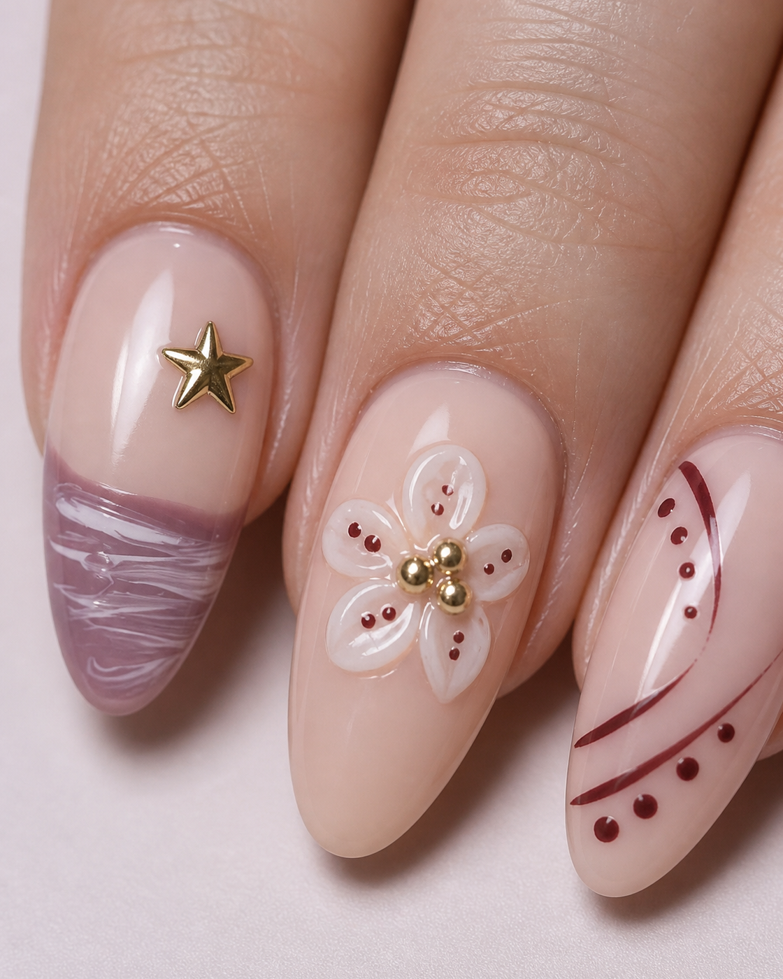 Close-up of Mauve Starlight flower, gold star, mauve ripple and curved-line nail details.