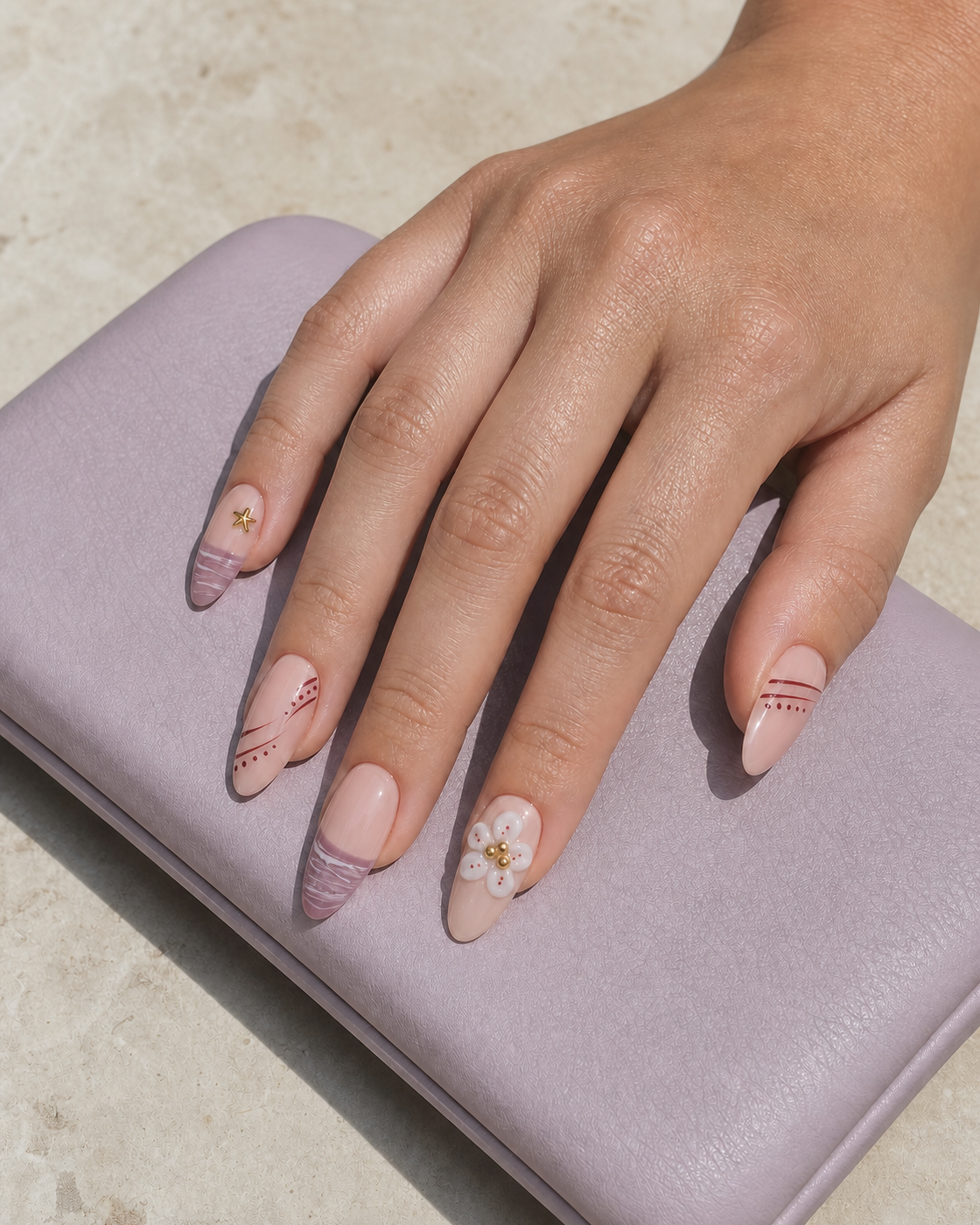Lifestyle view of a hand wearing Mauve Starlight almond press-on nails.