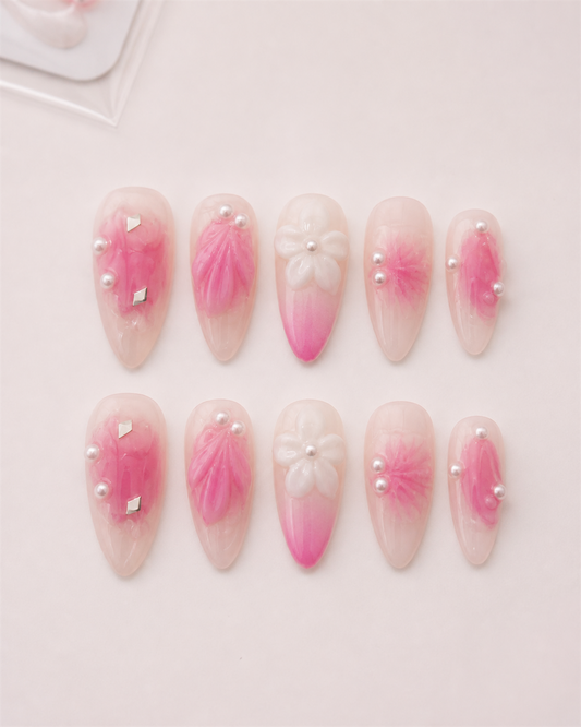 Ten Pink Petal Aura almond press-on nails arranged as a complete set.